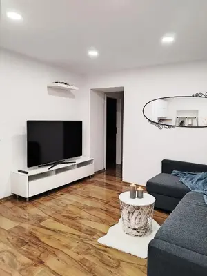 a living room with a television on a white wall at Stara Pošta Apartment 8 in Grosuplje