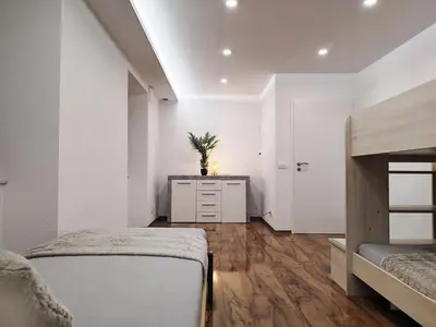 a bedroom with two beds and a dresser in it at Stara Pošta Apartment 8 in Grosuplje