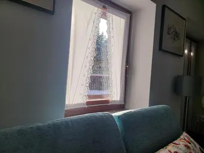 a window with a blue couch in a room at Apartma Modro gnezdo in Kranjska Gora