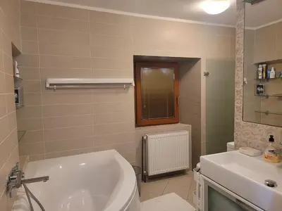 a bathroom with a white tub and a sink at Apartma Modro gnezdo in Kranjska Gora