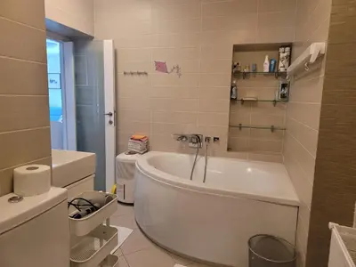 a white bathroom with a tub and a toilet at Apartma Modro gnezdo in Kranjska Gora