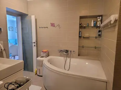 a bathroom with a tub and a toilet and a sink at Apartma Modro gnezdo in Kranjska Gora