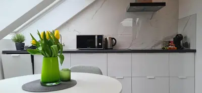 a vase with yellow flowers on a table in a kitchen at Relax & Enjoy Ljubljana in Ljubljana