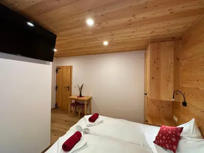 a bedroom with a bed with red pillows on it at Hotel ŠURC in Kranjska Gora