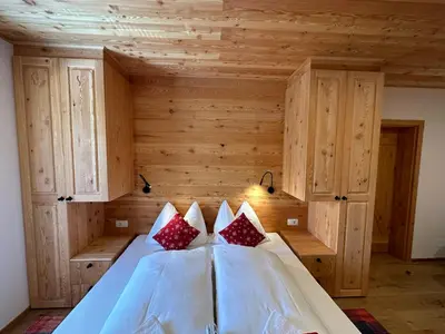 a bedroom with a bed in a room with wooden walls at Hotel ŠURC in Kranjska Gora