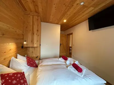 a bedroom with a bed with red pillows on it at Hotel ŠURC in Kranjska Gora