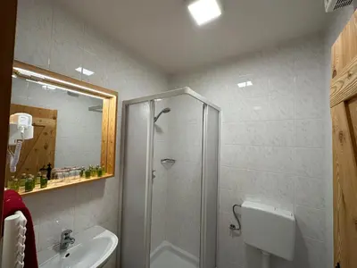 a bathroom with a shower and a sink at Hotel ŠURC in Kranjska Gora