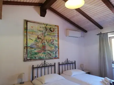 two beds in a bedroom with a painting on the wall at Pri Martinovih in Deskle