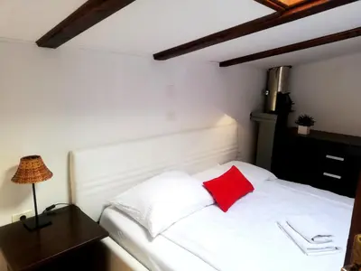 a bedroom with a white bed with a red pillow at Pri Martinovih in Deskle