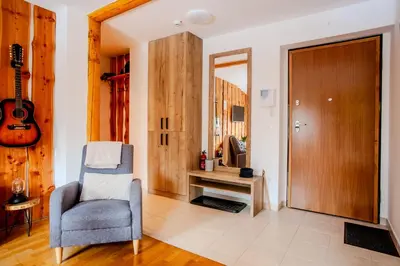 a living room with a chair and a guitar at APARTMA JEREBIKA ŠT. 20 in Pohorje