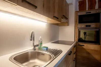 a kitchen with a sink and a microwave at APARTMA JEREBIKA ŠT. 20 in Pohorje