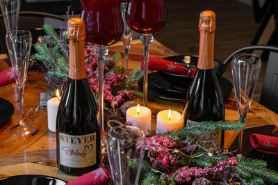 a table with two bottles of wine and candles at Apartments Gozdni Raj Rogla in Oplotnica