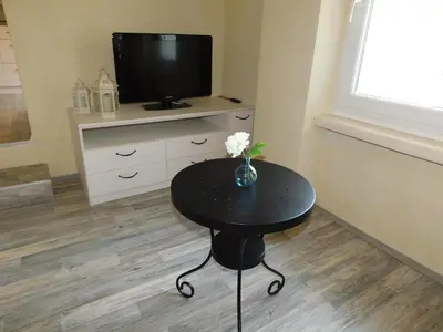 a small black table with a television on a cabinet at Old Town Theatre Staircase Apartments in Ljubljana