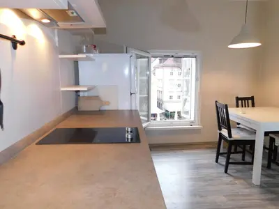 a kitchen with a table and a white refrigerator at Old Town Theatre Staircase Apartments in Ljubljana