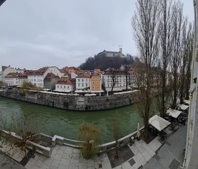 a view of a river with buildings and a town at Old Town Theatre Staircase Apartments in Ljubljana