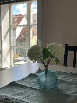 a blue vase with white flowers on a table at Old Town Theatre Staircase Apartments in Ljubljana