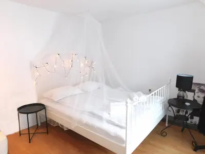 a white crib with lights in a bedroom at Old Town Theatre Staircase Apartments in Ljubljana