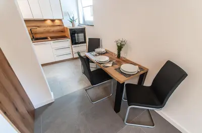 a dining room with a table and black chairs at Apartments Ursus in Bled