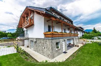 a house with a balcony on top of it at Apartments Ursus in Bled