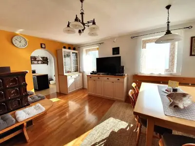 a living room with a dining table and a tv at House Pucnk-beautiful countryside in Železniki