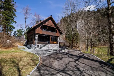 a house on a road in the woods at Holiday Home Iris in Zgornje Jezersko