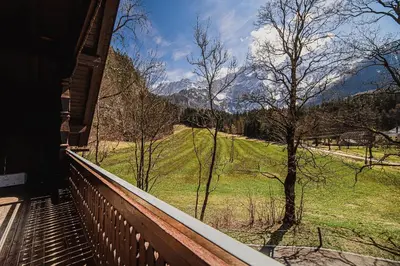 a balcony with a view of a field and mountains at Holiday Home Iris in Zgornje Jezersko