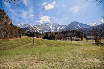 a field of grass with mountains in the background at Holiday Home Iris in Zgornje Jezersko
