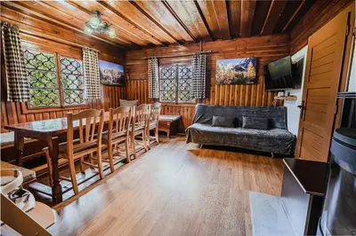 a living room with a couch and a table and chairs at Holiday Home Iris in Zgornje Jezersko