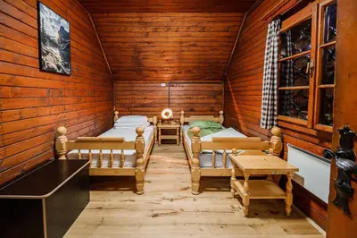 a room with two beds in a wooden cabin at Holiday Home Iris in Zgornje Jezersko