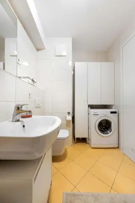a bathroom with a sink and a washing machine at Attractive Njegoševa Apartment with a Balcony in Ljubljana