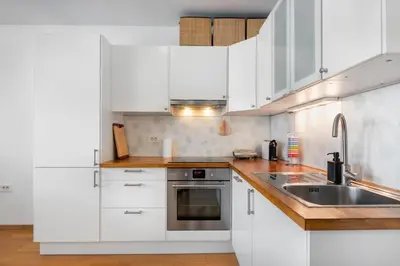 a kitchen with white cabinets and a sink at Attractive Njegoševa Apartment with a Balcony in Ljubljana
