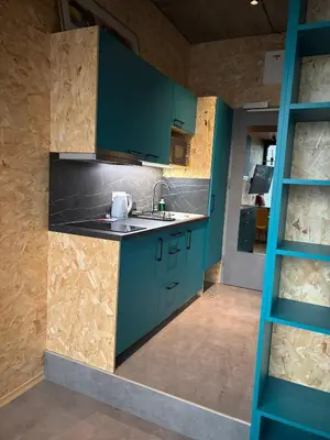a kitchen with green cabinets and a sink at Delo 2.0. in Ljubljana