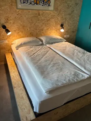 a large white bed in a room with lights at Delo 2.0. in Ljubljana