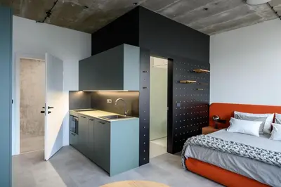 a bedroom with a bed and a sink and a kitchen at Delo 2.0. in Ljubljana