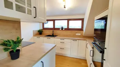 a kitchen with white cabinets and a counter top at Apartmaji Dora in Mojstrana