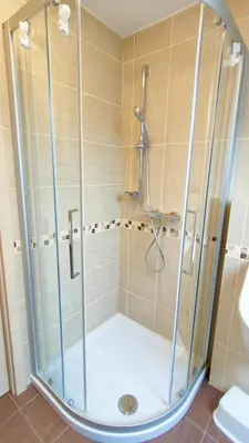 a shower with a glass door in a bathroom at Apartmaji Dora in Mojstrana