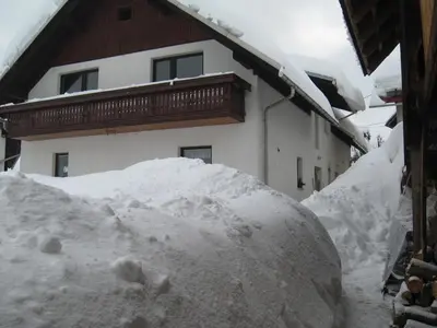 a pile of snow in front of a house at Apartma Tilika in Kranjska Gora