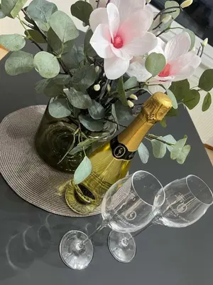 a bottle of champagne and glasses on a table with flowers at 47 Heaven Luxury House in Radovljica