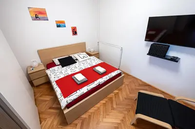a bedroom with a bed and a desk with a laptop at That Cat Flat - free parking, near city center, cats! in Ljubljana