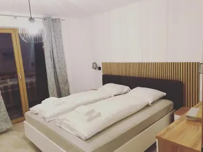 a bed with white pillows on it in a room at ALPS Apartments in Kranjska Gora