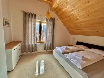 a bedroom with a bed and a wooden ceiling at ALPS Apartments in Kranjska Gora