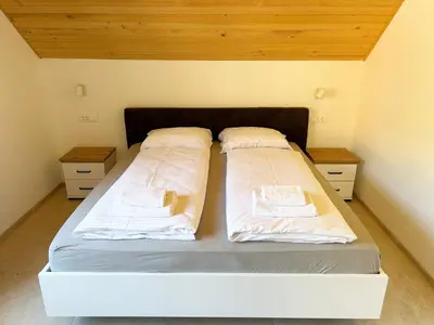 a bed with two pillows on it in a room at ALPS Apartments in Kranjska Gora
