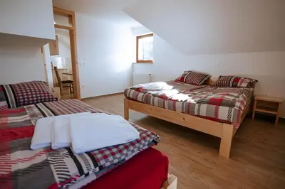 a room with two beds and a bedskirts at Apartments Čenda in Železniki