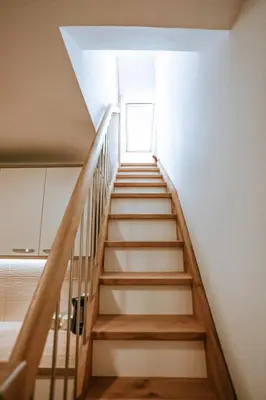 a staircase leading up to a room with a window at Apartments Čenda in Železniki