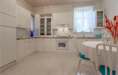 a white kitchen with a table and a white refrigerator at Beautiful Home In Obrov in Obrov