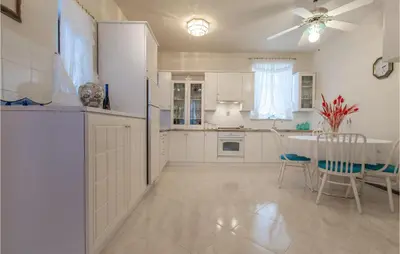 a kitchen with white cabinets and a table and chairs at Beautiful Home In Obrov in Obrov