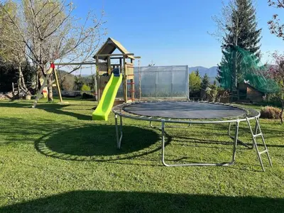 a trampoline with a slide on the grass at Apartment Sofia in Idrija