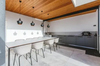 a kitchen with a long table and chairs at HIRUNDO- villa with saunas and hot tub in Sela pri Dobovi