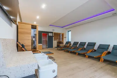 an empty waiting room with blue chairs in a room at HIRUNDO- villa with saunas and hot tub in Sela pri Dobovi
