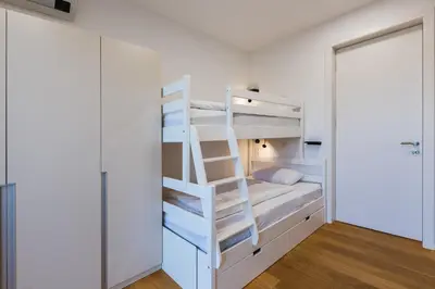 a white bunk bed in a white room with a ladder at HIRUNDO- villa with saunas and hot tub in Sela pri Dobovi
